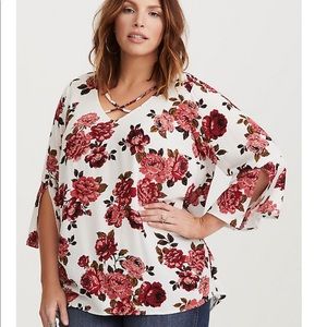 Torrid’s ivory floral split bell crepe blouse